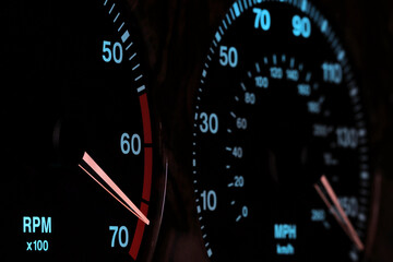 tachometer in car dashboard in red sphere at night