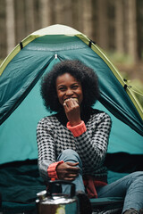 Laughing woman eating a snack while camping