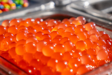 Bunch of red bobas with a flavor of pomegranate in a shop. Ingredient used to make bubble tea.