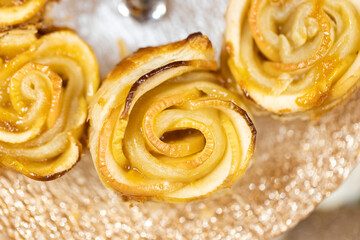 A group of baked apple roses on a tiered party tray.