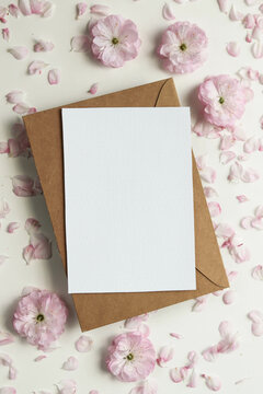 postcard mockup. frame of pink sakura flowers and white blank for text. wedding card. invitation