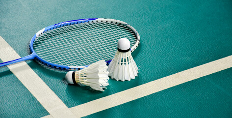 Badminton sport equipments on green indoor court, soft and selective focus, badminton lover concept.
