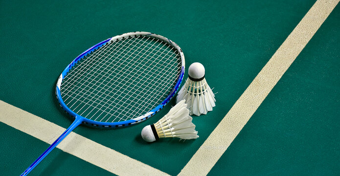 Badminton sport equipments on green indoor court, soft and selective focus, badminton lover concept.