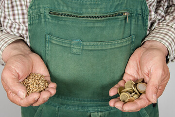 A farmer holds grain in his right hand and a handful of euro coins in his left. The high grain...