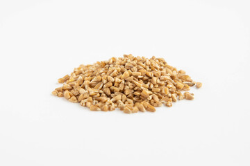 Handful of crushed whole wheat grain on a white background