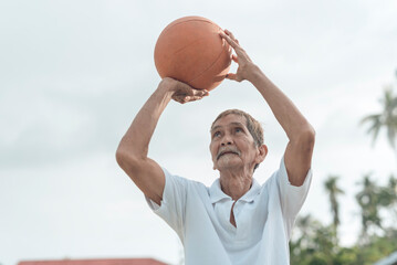 An old but spry basketball player shoots some hoops outdoors. Great 3 pointer form even in old age....