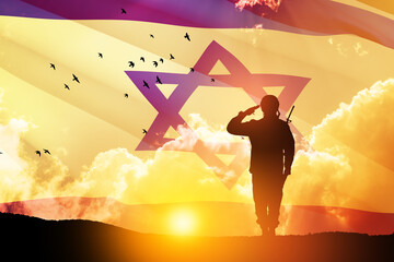 Silhouette of soldier saluting against the sunrise in the desert and Israel flag. Concept - armed...