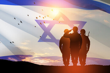 Silhouettes of soldiers saluting against the sunrise in the desert and Israel flag. Concept - armed...
