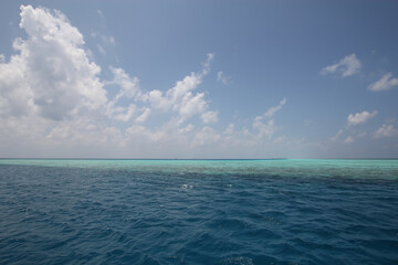 Maldives. Indian Ocean. Blue water and white clouds against a blue sky.