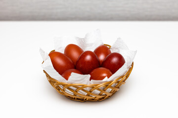red easter painted egg lies in a wicker basket   (Corrected)