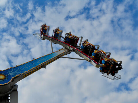 Fahrgesch&auml;ft mit &Uuml;berschlag auf Rummelplatz gegen Wolkenhimmel