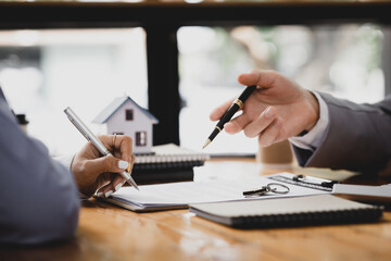 Rental company employee is discussing the details before the customer agrees to sign a rental contract, explaining the details and the terms and conditions of the rental. Real estate rental ideas.