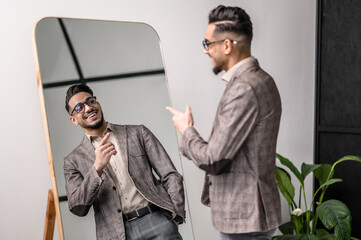 A good-looking young stylish man at the mirror