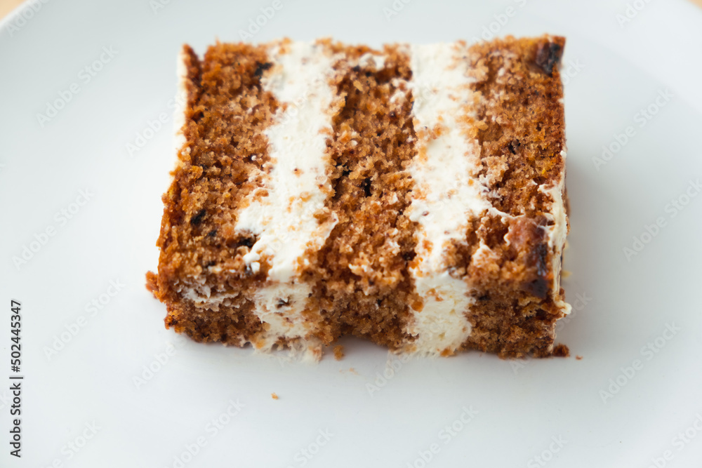 Wall mural close up shot of carrot sponge cake cut with cream cheese filling on the white background