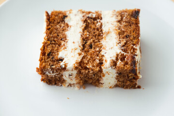 Close up shot of carrot sponge cake cut with cream cheese filling on the white background
