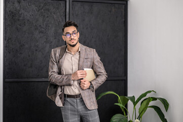 A man in a stylish jacket with some papers in hands