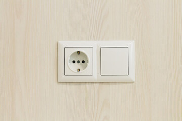 European electrical socket outlet and switch on wooden wall