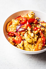Roasted vegetables salad with bulgur in white bowl. Vegan food concept.
