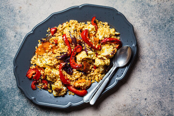Roasted vegetables salad with bulgur in gray dish, top view. Vegan food concept.