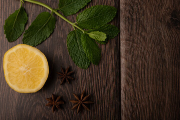 Lemon, mint and star anise on a dark wood background with copy space