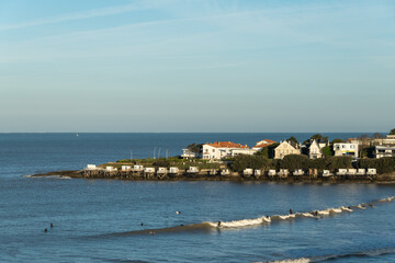 Royan, Charente-Maritime. Surfeurs au petit matin devant les carrelets et maisons typiques de la r&eacute;gion