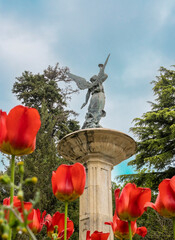La monumental fuente de la fama en el parque Campo Grande de Valladolid entre tulipanes rojos de su jardín, España - obrazy, fototapety, plakaty