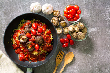 spaghetti in pan,Spaghetti pasta in tomato sauce with parsley chicken in a pan, chicken spaghetti pasta over black stone background with copy space, Italian food.