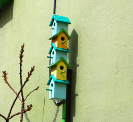Multicolored birdhouses. Decorative Colored Colorful houses for birds. Bird houses on the fence and wall.
