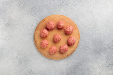 Obraz na płótnie Canvas Top view of raw meat balls on a wooden board