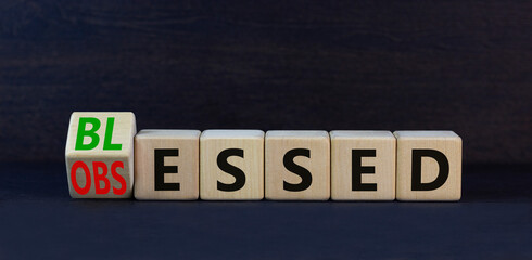 Obraz premium Blessed or obsessed symbol. Turned wooden cubes and changed the concept word Obsessed to Blessed. Beautiful black table black background. Business blessed or obsessed concept. Copy space.