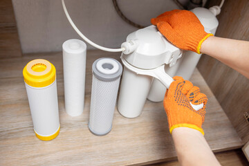 Plumber installs or change water filter. Replacement aqua filter. Repairman installing water filter...