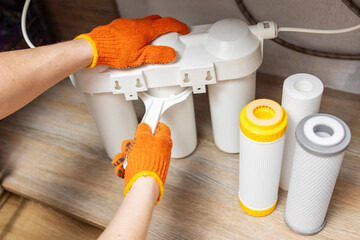 Plumber installs or change water filter. Replacement aqua filter. Repairman installing water filter...