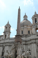 Fototapeta na wymiar Dome of Piazza Navona and the famous Fountain of the four rivers with obelisk in Rome