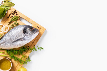 Fresh borabo fish with ingredients for cooking on white background top view. Copy space. Delicious and healthy food
