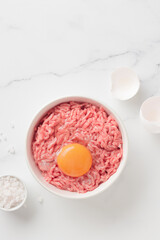 Cutlet ingredients beef farce meat with egg in a plate