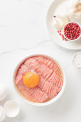 Cutlet ingredients farce meat with egg in a plate