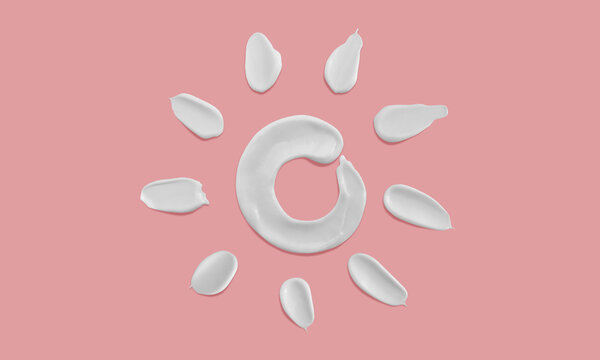 Sunscreen sun shape smears on pink background