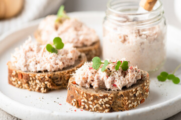 bruschetta with tuna pate, fish rillettes on a white plate , selective focus, close-up