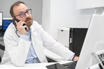 Fototapeta premium Doctor in office talking on phone. High quality photography.