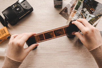 Old photo holding by a teenage girl, retro background with vintage camera, photos and film negative.