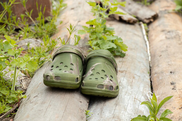 Plastic summer shoes for water and leisure camouflage on the grass on the wood in the summer in the...