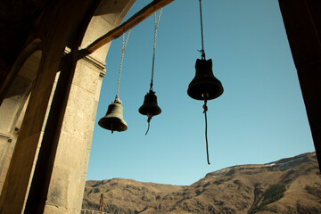 Bells against sky and mountains. Ropes for ringing. Bluebells of ancient world.