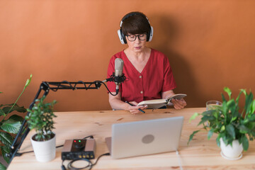 Middle-aged woman radio host making podcast recording for online show - broadcast and dj concept