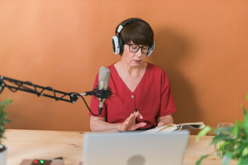 Middle-aged woman radio host making podcast recording for online show - broadcast and dj concept