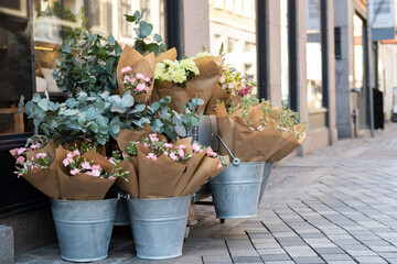 Eucalyptus branches and bouquets of flowers in buckets, decor.