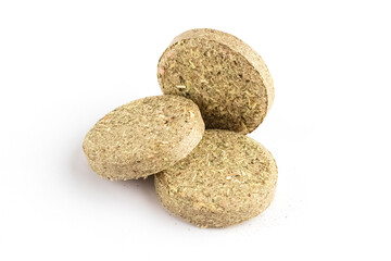 Tablets from pressed herbs on a white background. Concept, drug or food supplements. Close-up