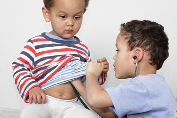 little boy playing doctors with his brother stock photo