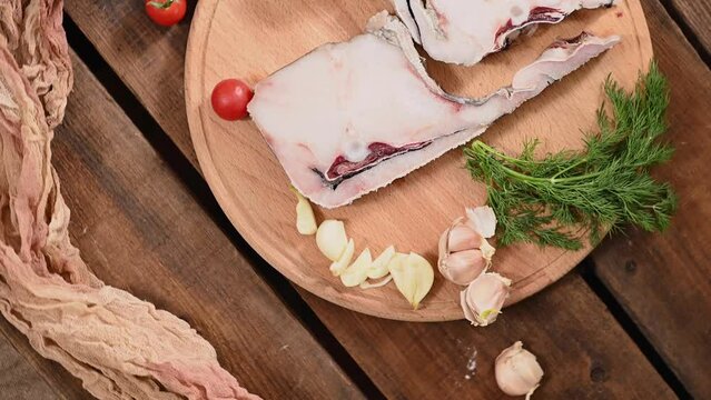 Raw fish cod on a tray, lemon tomato and pepper, wooden table in rustic style rotation. High quality 4k footage