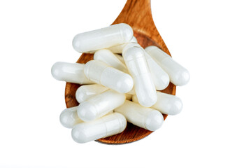Close up of vitamin D3 capsule or dietary supplement or medicine in wooden spoon over white background.