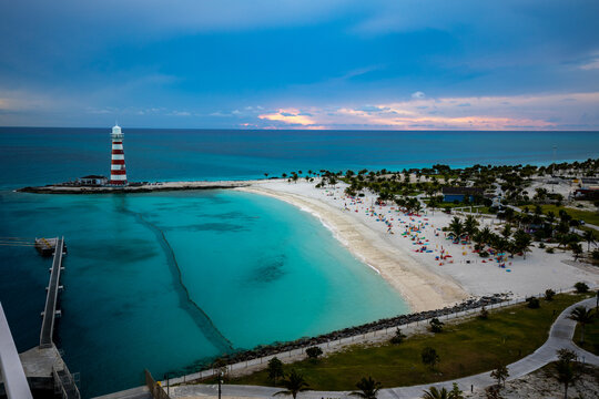 Sunset over a beach and a lighthouse on a private island in Bahamas